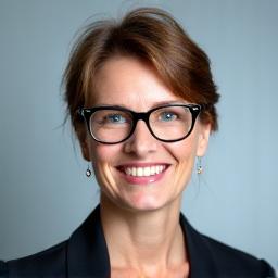Portretfoto van Eva Janssen, een vrolijke, professionele journalist met bril en een warme glimlach.